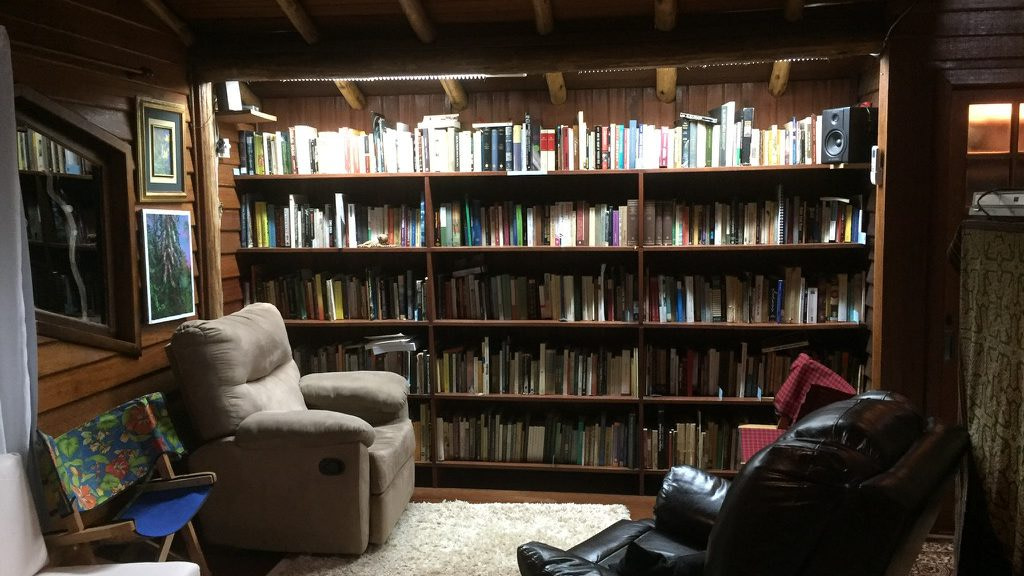 A living room with bookshelves and a chair.