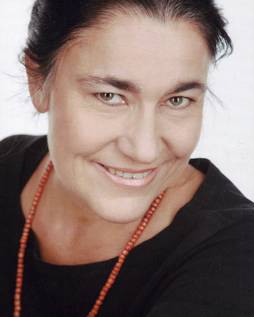 Dr. Claudia Müeller-Ebeling wearing a black shirt and a necklace.