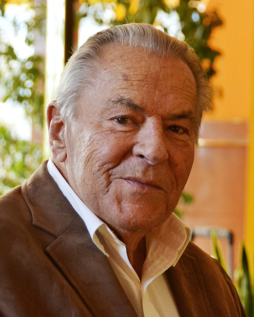 Dr. Stanislav Grof in a brown jacket and white shirt.